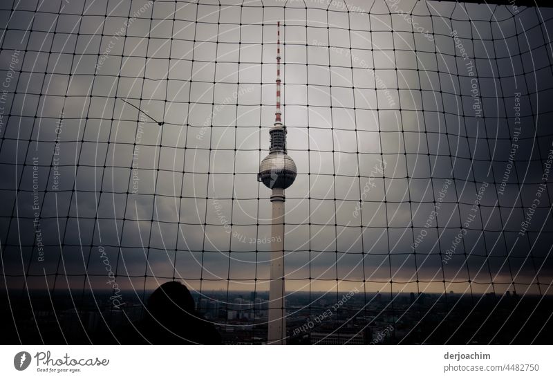 Der Berliner Fernsehturm von oben,  hinter einem Sicherheits Netz bei ganz schlechtem Wetter. Den Horizont sieht man nur noch als kleinen Lichtblick. Turm