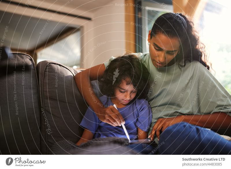 Mutter und Sohn benutzen Tablet auf dem Sofa gemischte Rasse asiatisch Tablette sich[Akk] entspannen Freizeit Bonden Zusammensein im Innenbereich Tag heimwärts