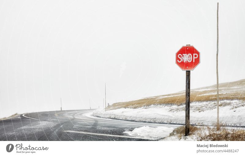 Stoppschild an einer Bergstraßenkreuzung während eines Schneesturms, selektiver Fokus, Colorado, USA. Straße stoppen Zeichen Verkehr Berge Laufwerk Gefahr