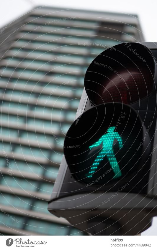 grüne Ampel für Fußgänger vor einem Hochhaus ampelmännchen Straßenverkehr leuchten Fußgängerampel gehen Sicherheit Design Silhouette Signal Verkehrszeichen