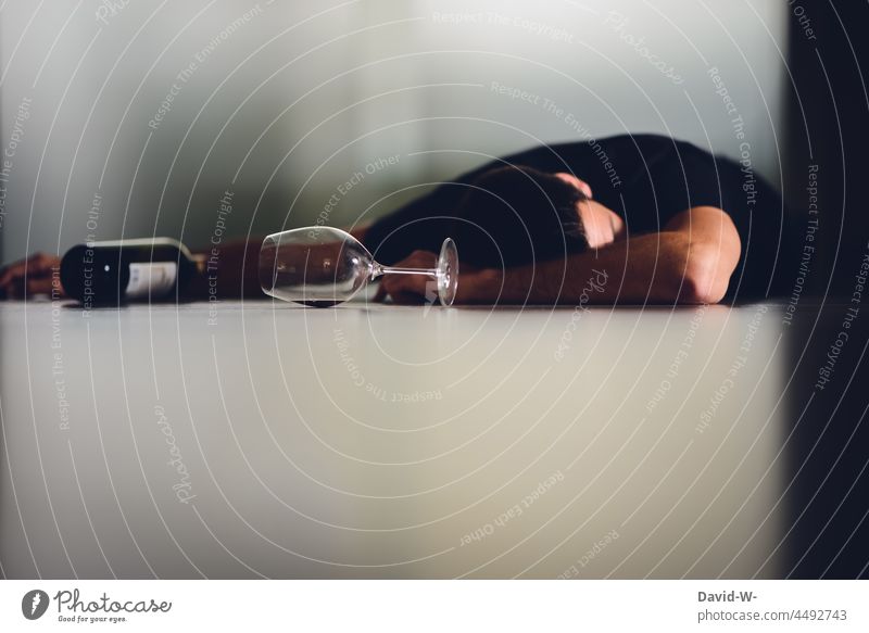 zu tief ins Glas geschaut Alkohol Mann betrunken Boden Wein Weinglas Alkoholiker Sucht schlafen Alkoholsucht Weinflasche eingeschlafen Frustration Verzweifelung