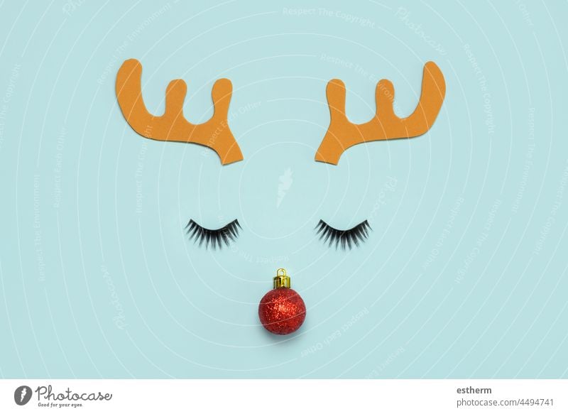 Frohe Weihnachten.Weihnachten Rudolph Rentier Hörner mit falschen Wimpern und rote Weihnachtskugel.Weihnachten Konzept Hintergrund Weihnachtsmann Spaß Feier