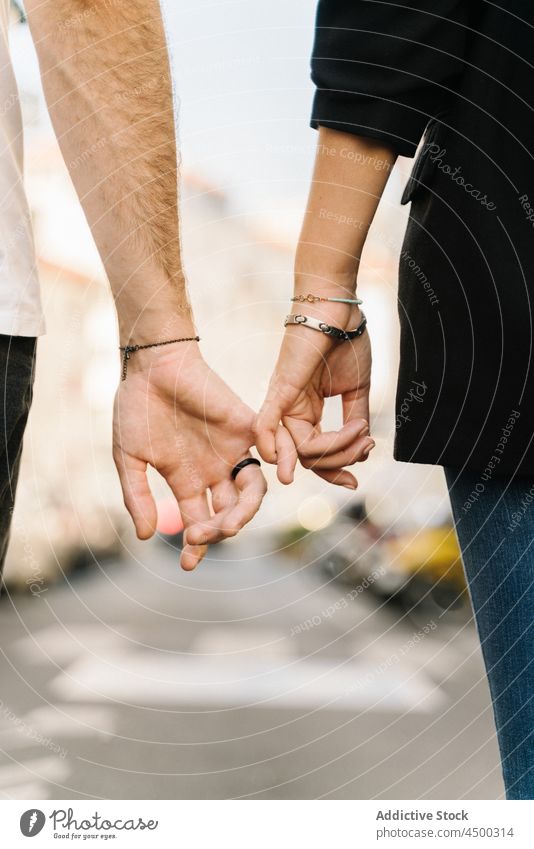 Anonymes Paar hält kleine Finger, während es auf der Straße spazieren geht Spaziergang Händchenhalten Partnerschaft Liebe Zusammensein Großstadt romantisch