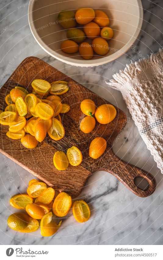 Haufen Kumquats auf Schneidebrett Frucht organisch natürlich gesunde Ernährung Zitrusfrüchte geschnitten Vitamin Küche frisch reif hölzern Gesundheit Murmel
