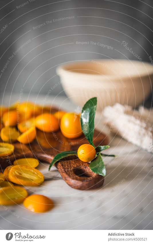 Haufen Kumquats auf Schneidebrett Frucht organisch natürlich gesunde Ernährung Zitrusfrüchte geschnitten Vitamin Küche frisch reif hölzern Gesundheit Murmel