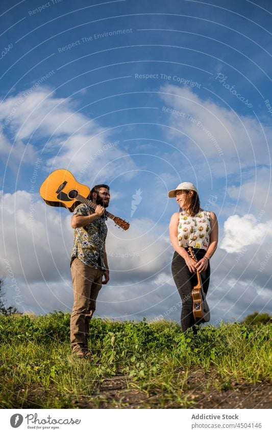 Musikanten stehen auf grünem Gras gegen blauen Himmel in sonnigen Tag Mann Frau Gitarre akustisch Instrument Musiker Ukulele Natur spielen männlich Sommer