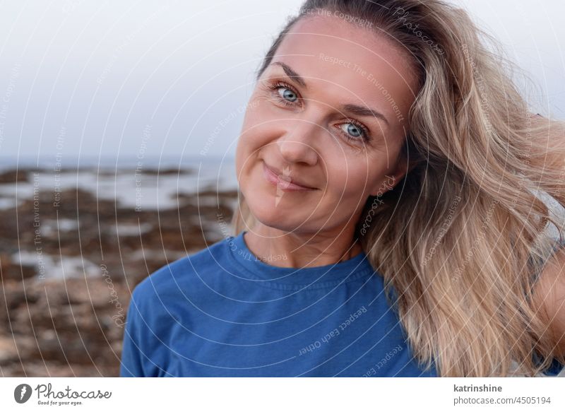 Frau mittleren Alters in der Nähe des Meeres MEER T-Shirt im Freien blondhaarig blau Lächeln Sonnenuntergang Kaukasier Erwachsener heiter Fröhlichkeit Mutter