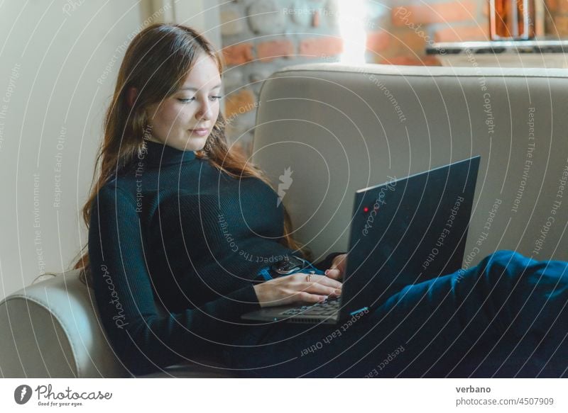 junge kaukasische Frau am Computer, die auf einem Sofa arbeitet, gemütlich zu Hause heimwärts Laptop Internet Technik & Technologie Lifestyle lässig Glück schön