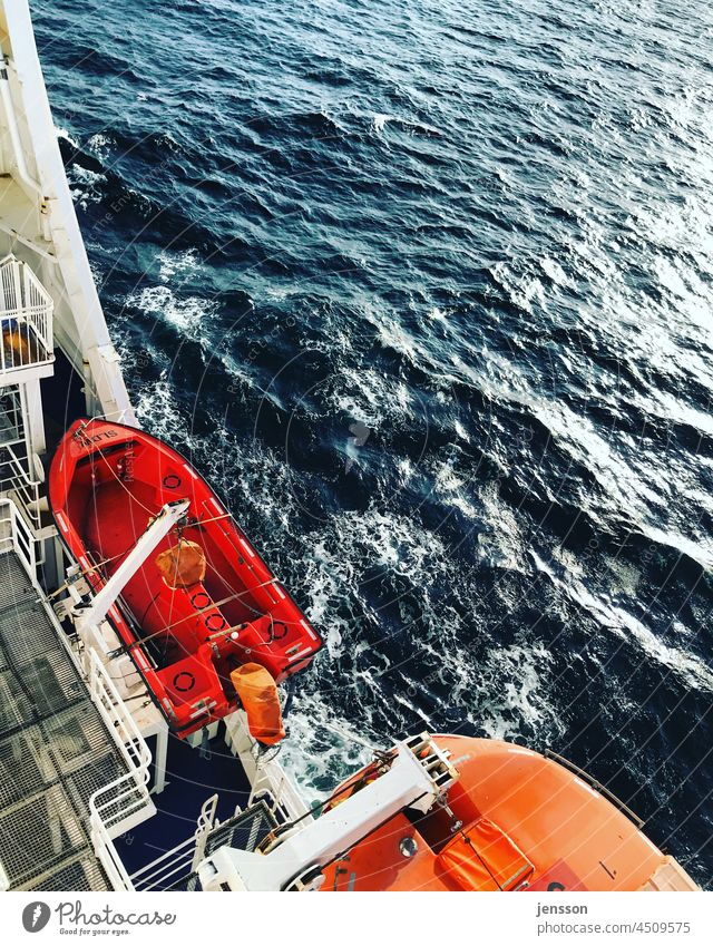Rettungsboote auf einer Fähre über die Ostsee Meer retten Sicherheit Wasser Meerwasser Schifffahrt rot leuchtende Farben sonnig Sonnenlicht glitzerndes Wasser