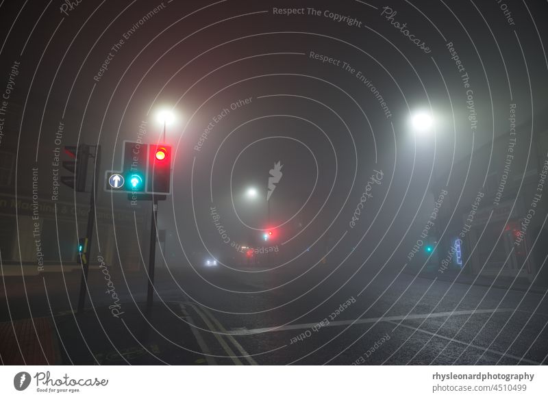 Unglaublich dichter Nebel an einer Straßenkreuzung in Broomhill, Sheffield. Dort, wo die Fulwood Road auf die Whitham Road und die Crookes Road auf die Nile Road trifft. Ampel leuchtet in den nebligen Vordergrund. Dunkle Nachtszene.