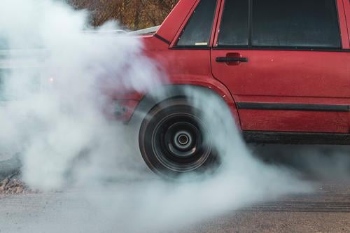 die Reifen verbrennen PKW Burnout rotes Auto Reifenverbrennung Reifen in Bewegung Farbfoto Gummi Bewegung eines Reifens brennend Rad Autoreifen fahren Fahrzeug