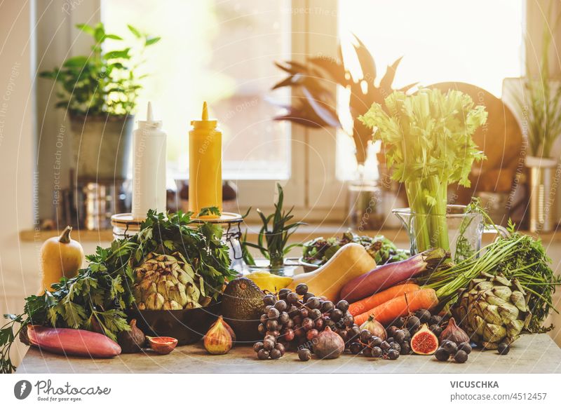 Verschiedene Lebensmittel am Fenster Hintergrund: Weintrauben, Karotten, Artischocken, Avocado, Feigen und Kürbisse. Nachhaltiger Lebensstil mit unverpacktem gesundem Gemüse und Obst. Vorderansicht.