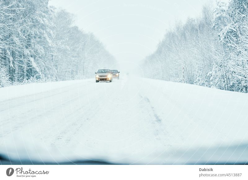 Verschneite Straße im Winterwald mit fahrendem Auto PKW Wetter verschneite Verkehr Schnee Eis im Freien Wald Frost Fahrzeug Automobil Schneesturm Bremse kalt