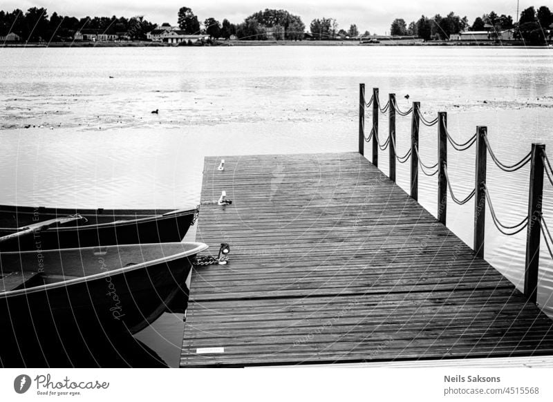Zwei alte Ruderboote am Steg, monochrom schwarz-weiß abstrakt Hintergrund Strand schön Boot Bootfahren Boote Brücke Windstille Kanusport Wolken dreckig Dock