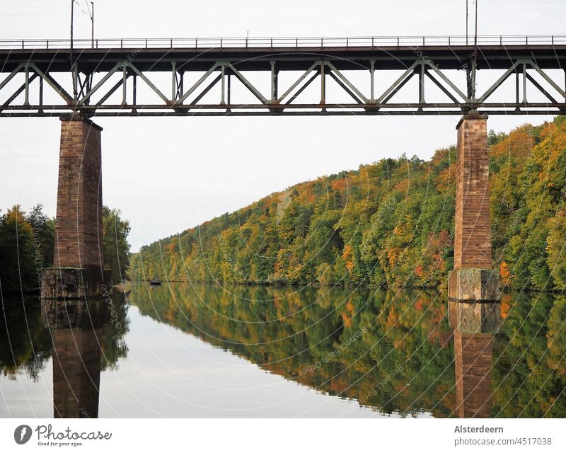 Eisenbahnbrücke über die Fulda bei glattem Wasser spiegeln sich die Herbstbäume im Wasser Brücke Fluss Reflexion glattes Wasser Flusswasser Außenaufnahme