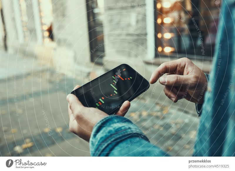 Mann, der in den Aktien- und Kryptowährungsmarkt investiert, indem er die Investitionsanwendung auf seinem Smartphone nutzt Brühe Markt Investierung Handel