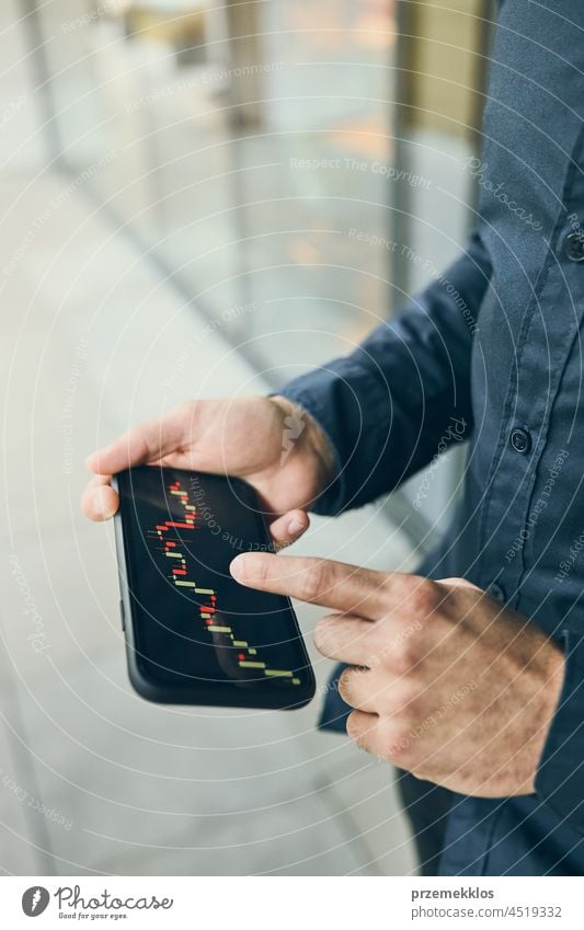 Mann, der in den Aktien- und Kryptowährungsmarkt investiert, indem er die Investitionsanwendung auf seinem Smartphone nutzt Brühe Markt Investierung Handel