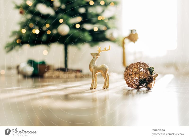 Goldene Hirsche und Weihnachtskugeln auf dem Hintergrund des Weihnachtsbaums, Details der Dekorationen. Weihnachten Stillleben, Winter Zusammensetzung Rentier