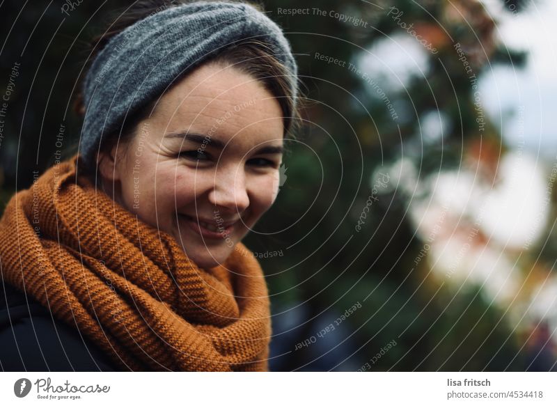 GRINSEN - JUNGE FRAU - HERBST Frau 30-35 Jahre grinsen hübsch Stirnband Schal Herbst freundlich schön Erwachsene Farbfoto Außenaufnahme Blick in die Kamera