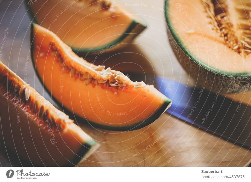 Cantaloupe-Melone wird aufgeschnitten Messer Scheibe aufschneiden Achtel Viertel orange grün Frucht gesund Lebensmittel frisch Gesundheit Ernährung reif saftig