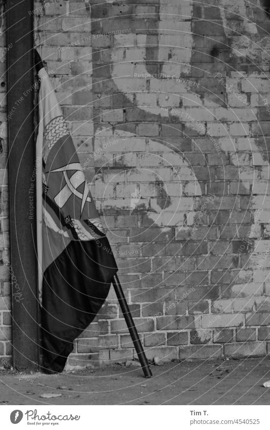 eine DDR Fahne steht angelehnt an einer alten Fabrikmauer GDR Berlin Deutschland DDR-Flagge Architektur historisch Osten Hauptstadt Stadt Vergangenheit