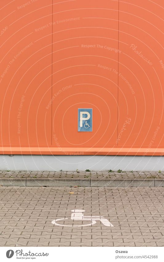 Behindertenparkplatz Parkplatz Behindertengerecht Rollstuhl Rollstuhlgerecht Piktogramm Schild Pflastersteine Bordstein Fassade Wand rot orange blau Rücksicht