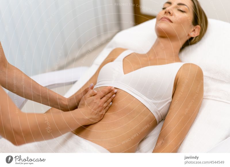 Frau mittleren Alters bei einer Bauchmassage in einem Schönheitssalon. Massage Unterleib Menschen Spa Körper sich[Akk] entspannen massierend Masseur