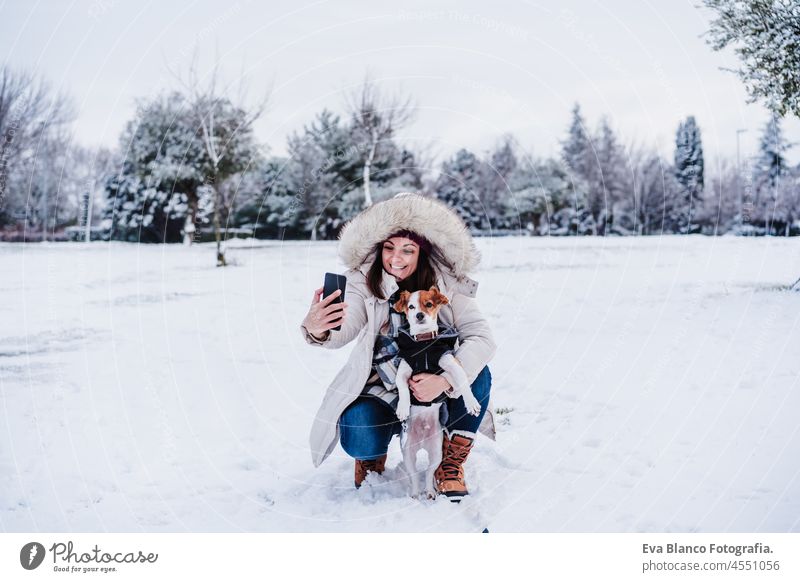 glückliche Frau in verschneiten Berg fotografieren mit Handy mit niedlichen Jack Russell Hund. Wintersaison. Spaß im Schnee jack russell Selfie Technologie