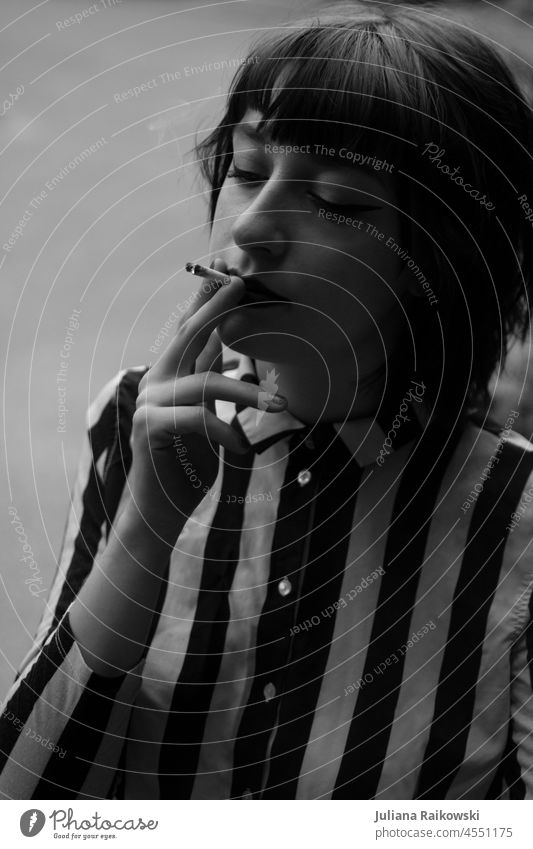 junge Frau raucht in schwarz weiß Rauch Zigarette Rauchen Porträt ungesund gesundheitsschädlich Gesundheitsrisiko Abhängigkeit Sucht Nikotin Nikotingeruch
