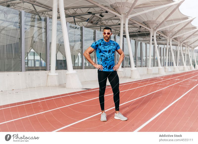 Sportlicher Mann auf der Laufbahn stehend gutaussehend jung ethnisch Afrikanisch Amerikaner männlich Sonnenbrille Sportbekleidung Stehen sportlich Bahn