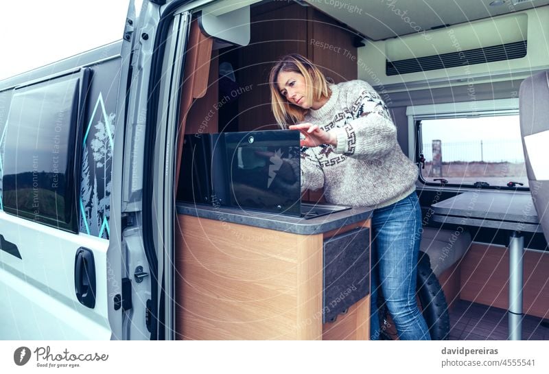 Frau reinigt Küche eines Wohnmobils mit einem Lappen jung Reinigen Kleintransporter Stoff ordentlich Perfektionist Hand Menschen Innenbereich Automobil