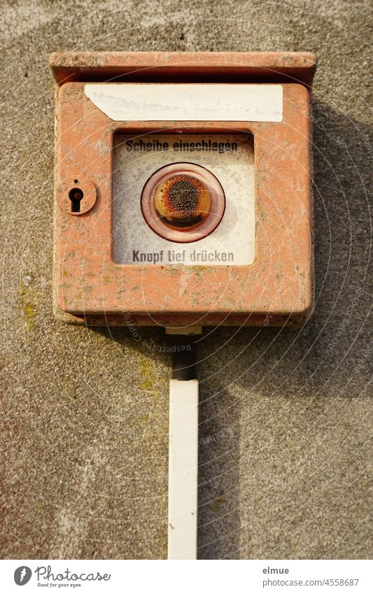 defekter, rostender, historsicher Feuermelder an einer Wand / Brandmelder / Feueralarm Technik historisch alt Erinnerung kaputt Knopf drücken