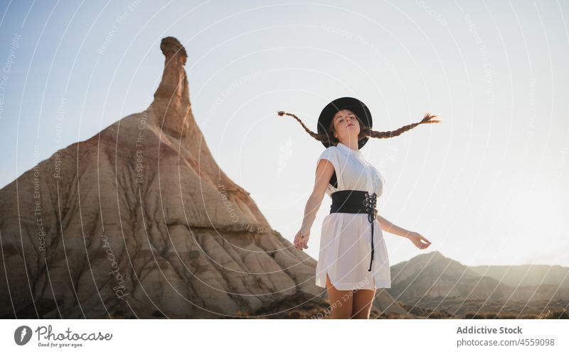 Unbeschwerte Frau mit wehenden Zöpfen in der Nähe des Berges von Bardenas Reales Spanien Park Natur Glück Berge u. Gebirge castelditierra Navarra Klippe