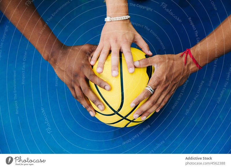 Crop gesichtslos diverse Spieler setzen Hände auf Ball Mann Basketball Streetball Aktivität Zusammensein Team Hand Sport spielen Konkurrenz vorbereiten Gericht