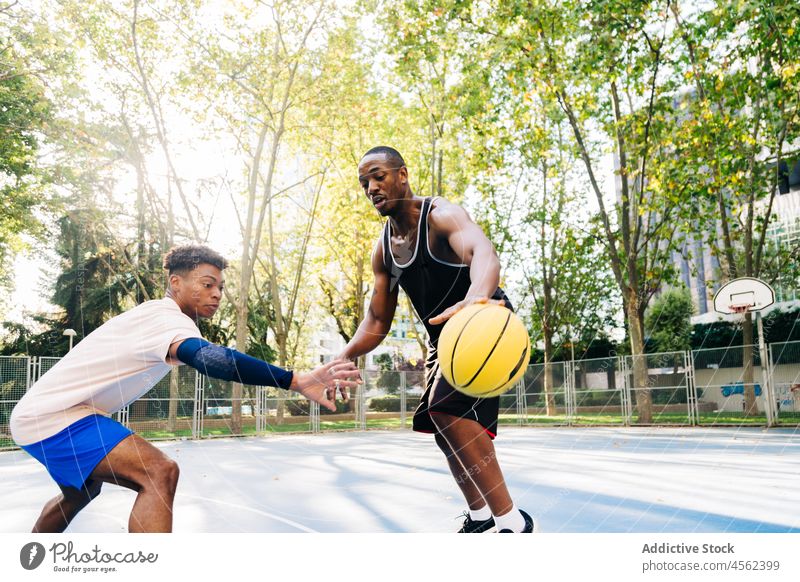 Schwarze ethnische Sportler, die beim Basketballspielen mit dem Ball laufen Männer Freund Sportpark Spieler Zusammensein Gericht Team Training Aktivität