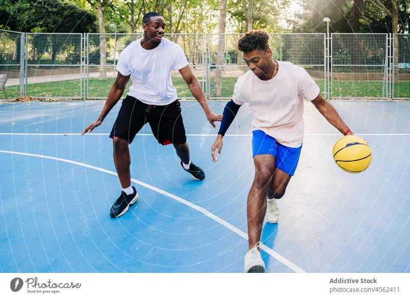 Schwarze ethnische Sportler, die beim Basketballspielen mit dem Ball laufen Männer Freund Sportpark Spieler Zusammensein Gericht Team Training Aktivität