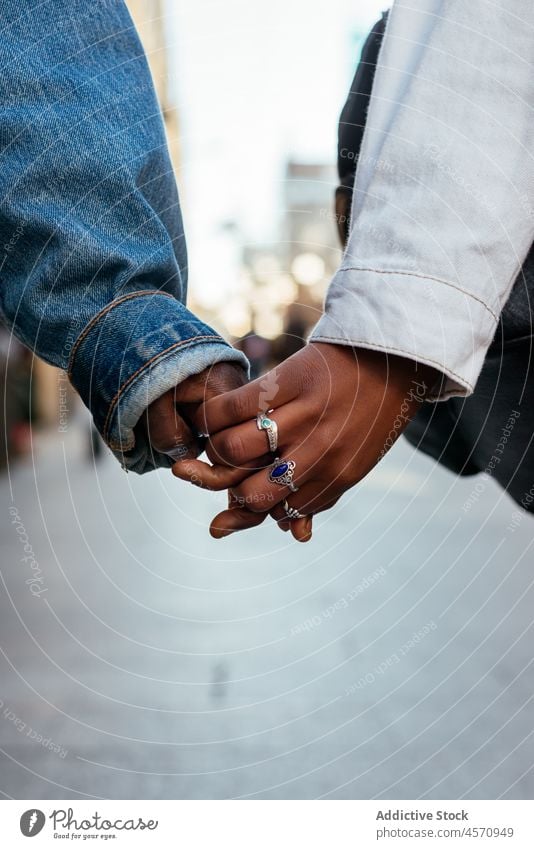 Anonyme ethnische Frauen halten sich bei einem Spaziergang auf einer belebten Straße an den Händen Schwester Freund lgbt schlendern Paar lesbisch Zusammensein