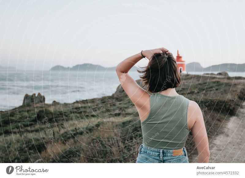 Rückenansicht Sonnenuntergang junge Frau geht auf dem Weg der Felsen am Ufer und blickt auf den Abend sea.Young Hipster Mädchen tun einige Wanderungen an der Küste, Reisen und Low-Budget-Reise-Konzepte, Kopie Raum