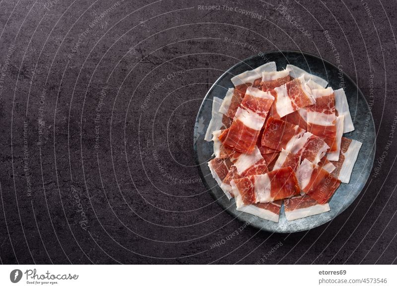 Spanischer Serrano-Schinken in Scheiben auf schwarzem Teller Frühstück Aufschnitt geheilt Schneidebrett Feinkostladen lecker Europa Lebensmittel Gastronomie