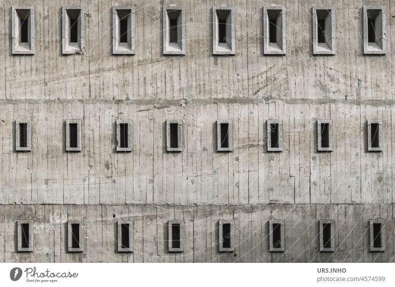 die graue Fassade eines Bunkers mit vielen kleinen Fenstern wirkt minimalistisch Gebäude Architektur Bauwerk Außenaufnahme Menschenleer Wand trist