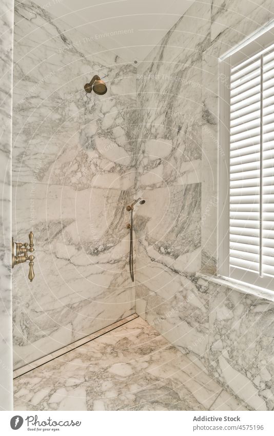 Duschkabine mit marmorgefliesten Wänden und modernem Wasserhahn Dusche Kabine Bad Murmel Innenbereich sehr wenige Design Hygiene Waschraum Stil wohnbedingt