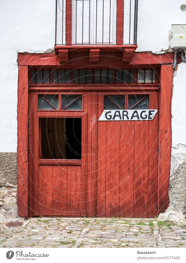 Altes weisses Gebäude mit rotem Tor und der Aufschrift "Garage" Haus Fassade Wand Farbfoto Tür Außenaufnahme Mauer Garagentor Einfahrt Ausfahrt Tag Menschenleer