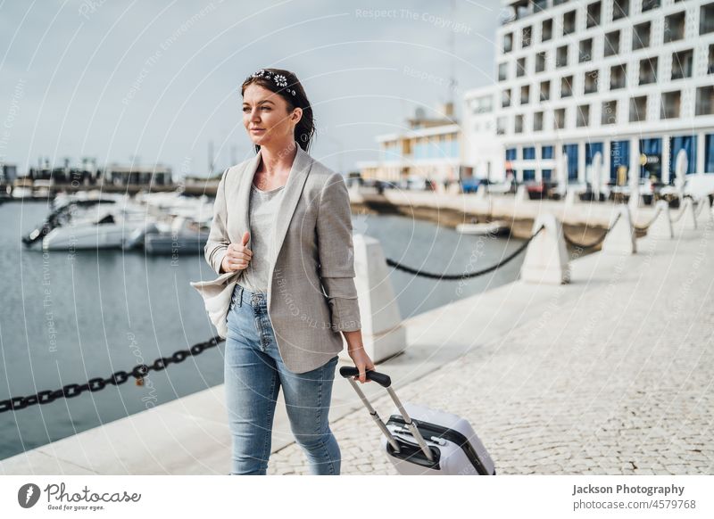Junge Frau mit einem Koffer beim Spaziergang in einer städtischen Umgebung. reisen Tasche Tourist Abenteuer Algarve Freiheit jung Briten Backpacker natürlich