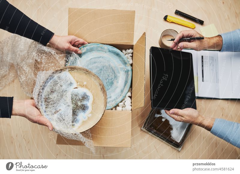 Geschäftsinhaber, der eine Online-Bestellung für die Lieferung an den Kunden verpackt. Vorbereitung Paketkasten mit Keramikplatte Produkt Onlineshop Versand