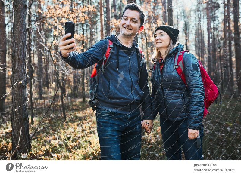 Paar nimmt Selfie Foto während Urlaub Reise. Wanderer mit Rucksäcken zu Fuß auf dem Weg im Wald an einem sonnigen Tag Ausflug wandern Abenteuer reisen unter