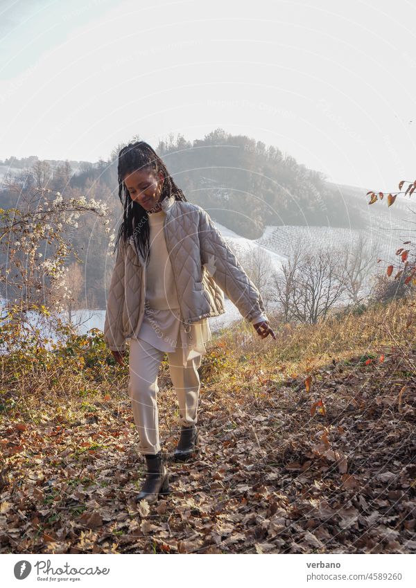 glückliche junge afrikanische elegante Frau, die in einer Berglandschaft spazieren geht Afrikanisch Rastalocken schwarz schön heiter Glück Erwachsener