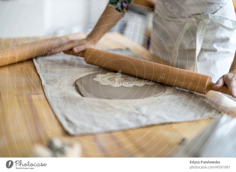 Nahaufnahme einer Kunsthandwerkerin bei der Arbeit an ihrer Töpferware in einer Werkstatt Hände abschließen Konzentration Geduld Topf traditionell Leiste