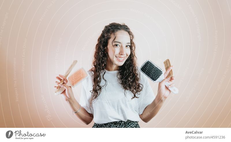 Close-up-Porträt junge afrikanische Frau nett aussehende wavy-haired Mädchen hält in der Hand Holzkamm isoliert auf Farbe Pastell Hintergrund. Kopieren Raum, Haare Konzept Schönheit. Werbung