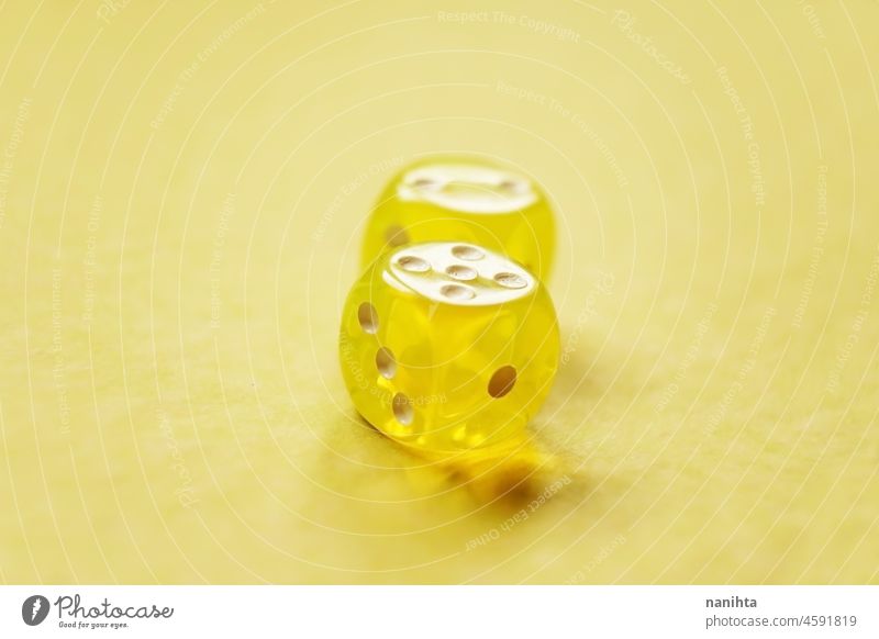 Ein lebhaftes monochromatisches Makro mit Tiefenschärfe über zwei gelbe Glaswürfel mit zwei Zahlen, zwei und fünf, auf gelbem Hintergrund. Würfel Glück