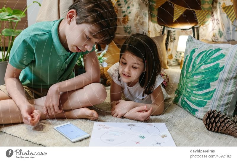 Brüder spielen Schatzsuche in einem selbstgebauten Zelt zu Hause Heimaturlaub Kinder Diy-Zelt Lager Schatzsuchspiel Spaß zu Hause Landkarte mobiler Kompass